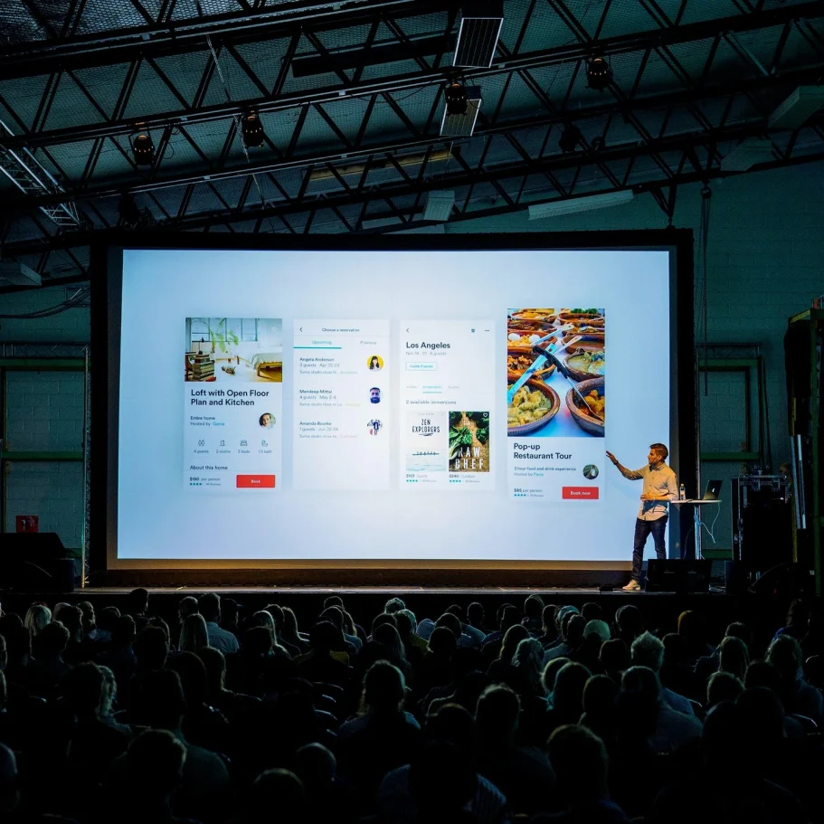 Eventreinigung Präsentation mit Diagramm auf einer großen Leinwand vor einem Publikum.