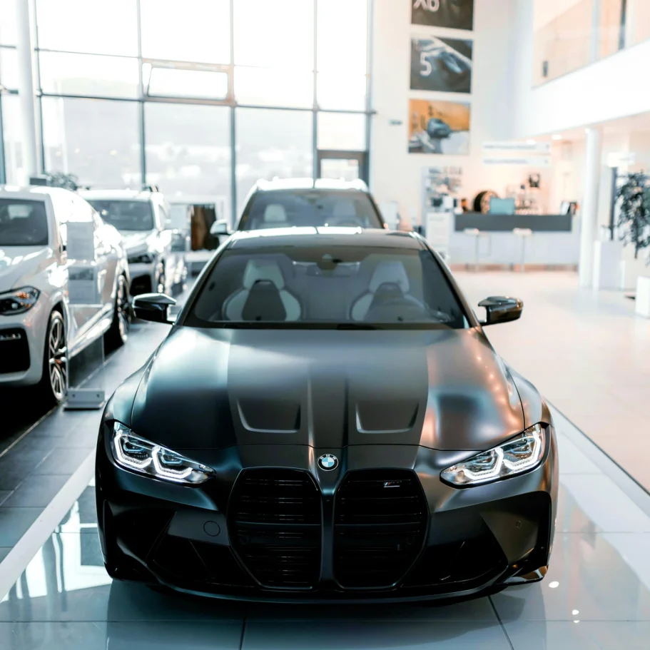 Showrooms & Verkausflächen Schwarzer BMW in einem eleganten Autohaus mit weiteren Fahrzeugen im Hintergrund.